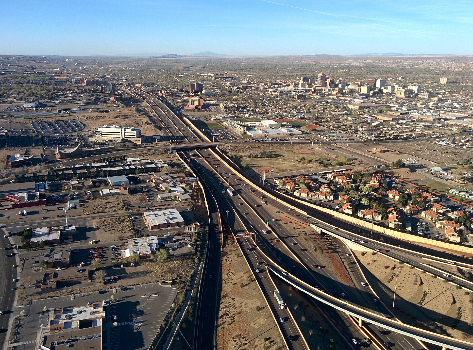 Aerial view of I-25 approaching downtown Albuquerque with distant mountains